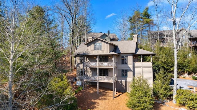 rear view of property with a chimney and a balcony