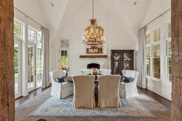 1877 Bowery Rd, Highlands, NC 28741 - dining area with a chandelier, wood finished floors, high vaulted ceiling, and a warm lit fireplace