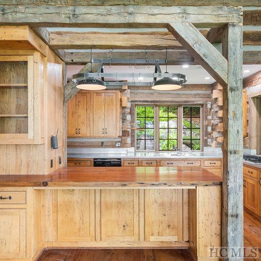 kitchen with light brown cabinetry, wood-type flooring, dishwasher, and butcher block counters