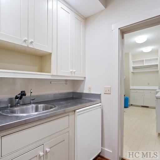 kitchen with sink, white cabinetry, and dishwasher