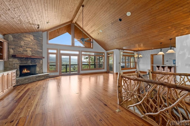 living room featuring light wood-type flooring, a fireplace, high vaulted ceiling, and wooden ceiling