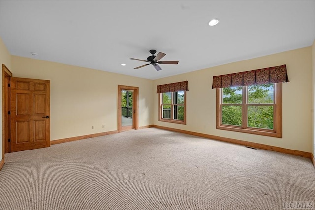 carpeted spare room with ceiling fan and a healthy amount of sunlight