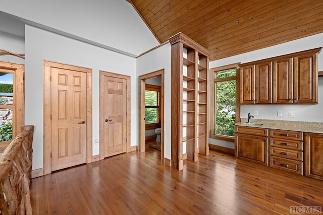 kitchen featuring wooden ceiling, dark hardwood / wood-style floors, light stone countertops, and a wealth of natural light