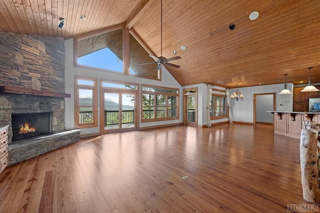 unfurnished living room with high vaulted ceiling, a stone fireplace, wood ceiling, and light hardwood / wood-style flooring