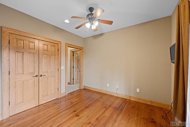 unfurnished bedroom featuring light hardwood / wood-style flooring, ceiling fan, and a closet