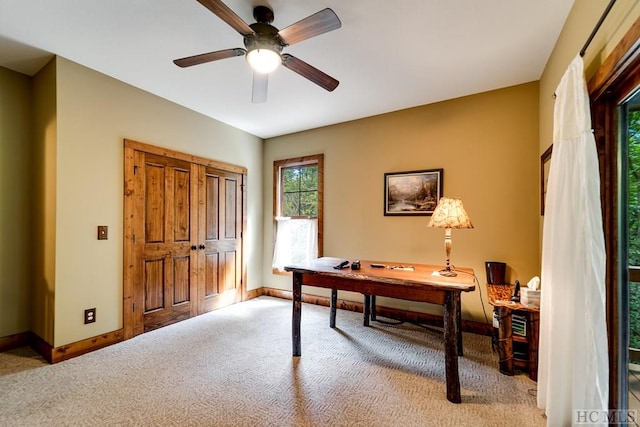 carpeted office space with ceiling fan