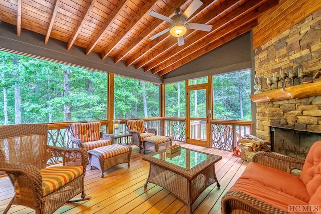 sunroom / solarium with ceiling fan, wooden ceiling, a fireplace, and vaulted ceiling with beams