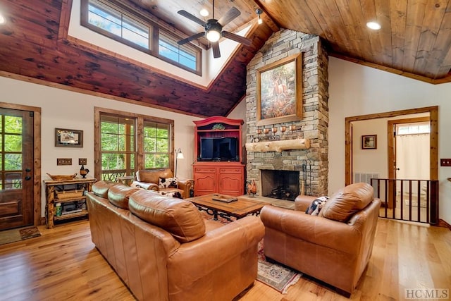 living room featuring a stone fireplace, high vaulted ceiling, light hardwood / wood-style floors, and beamed ceiling