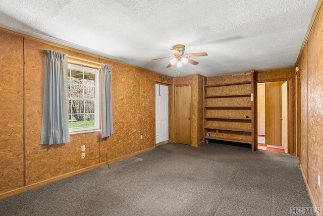 carpeted empty room with ceiling fan and a textured ceiling