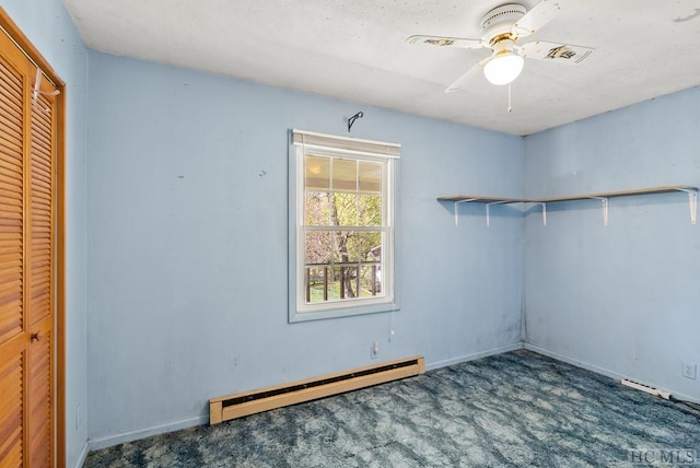 spare room with ceiling fan, carpet flooring, and a baseboard heating unit