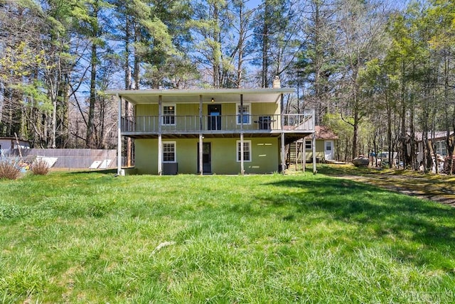 rear view of property with a wooden deck and a lawn