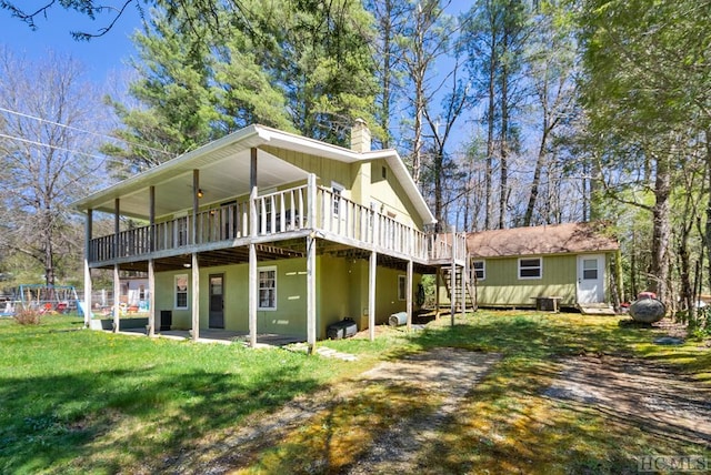 back of property featuring a yard and a wooden deck