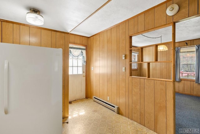 interior space with wood walls and a baseboard radiator