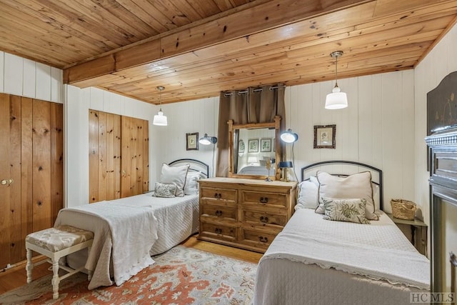 bedroom with wood ceiling, beamed ceiling, wood walls, and light hardwood / wood-style floors