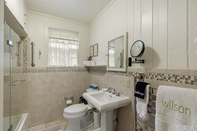 full bathroom featuring toilet, tile walls, sink, plus walk in shower, and ornamental molding