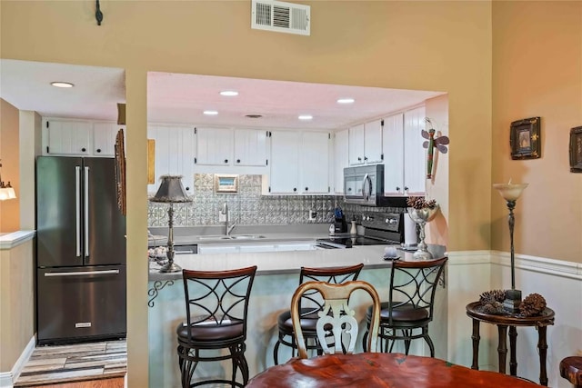 369 Meadow Way Unit 1713, Sapphire, NC 28774 - kitchen with high end fridge, black range with electric cooktop, a peninsula, tasteful backsplash, and white cabinetry