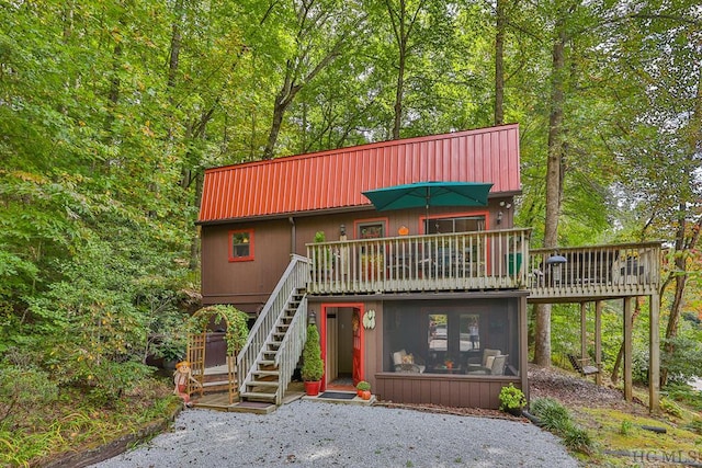 view of front of home featuring a sunroom and a deck