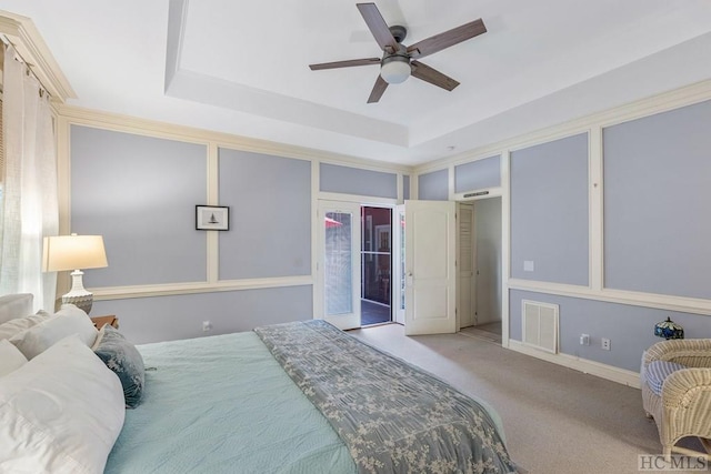 bedroom featuring light carpet, a raised ceiling, and ceiling fan