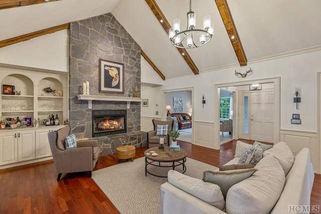 living room featuring built in features, vaulted ceiling with beams, dark hardwood / wood-style floors, a notable chandelier, and a fireplace