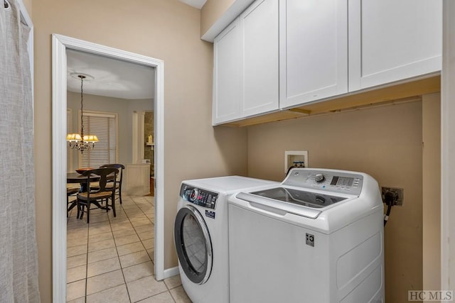 laundry area featuring light tile patterned floors, a notable chandelier, cabinets, and washing machine and clothes dryer