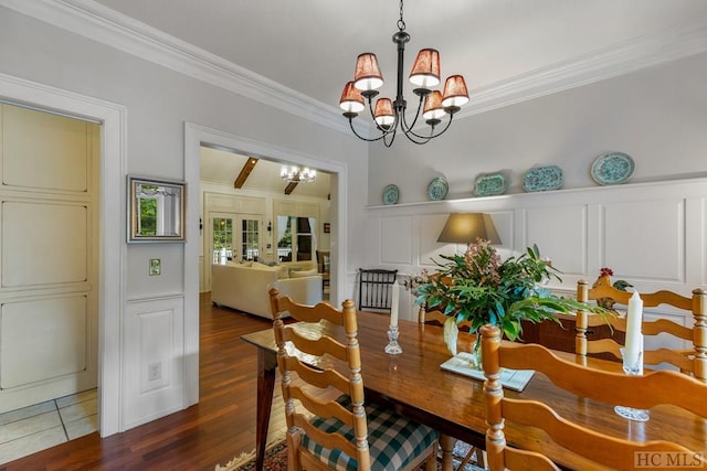 dining room with crown molding, dark hardwood / wood-style floors, an inviting chandelier, and french doors