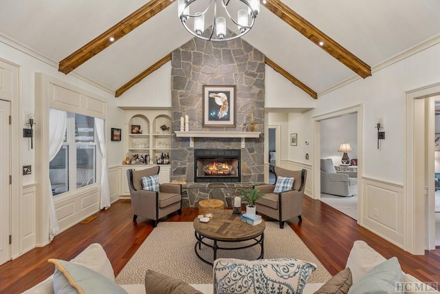 living room featuring built in features, a fireplace, vaulted ceiling with beams, a notable chandelier, and dark wood-type flooring