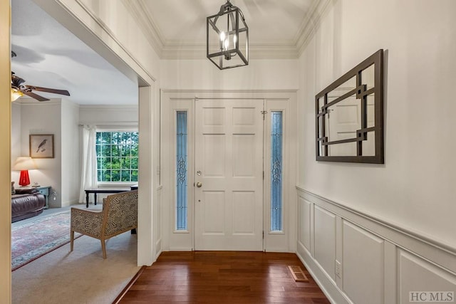 entryway featuring crown molding, dark hardwood / wood-style flooring, and ceiling fan with notable chandelier