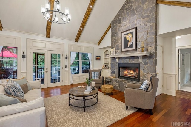 living room featuring beam ceiling, dark hardwood / wood-style floors, a fireplace, and french doors