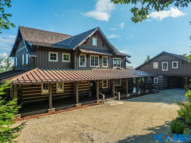 back of house featuring a porch and a standing seam roof