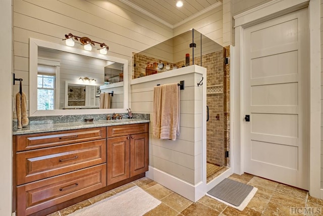 bathroom with ornamental molding, a shower with door, wood walls, and vanity