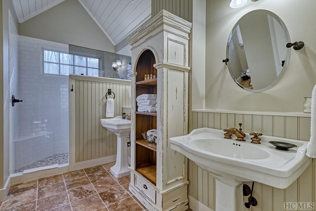 bathroom featuring lofted ceiling, sink, crown molding, and tiled shower