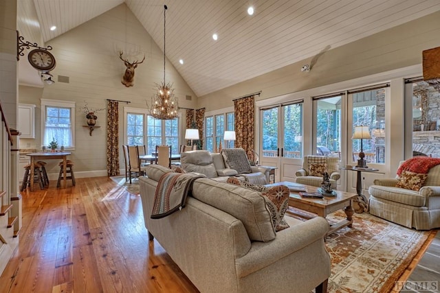 living room featuring wooden ceiling, high vaulted ceiling, a notable chandelier, and light hardwood / wood-style floors