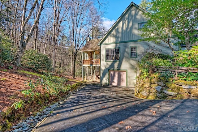 view of side of property featuring a garage and a balcony