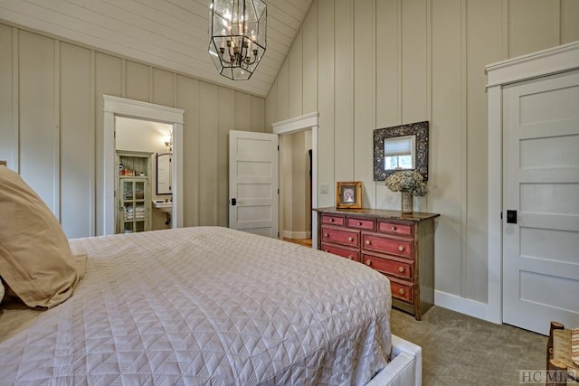 carpeted bedroom featuring vaulted ceiling, connected bathroom, and a chandelier