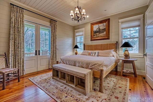 bedroom featuring light hardwood / wood-style flooring, crown molding, french doors, and wood ceiling