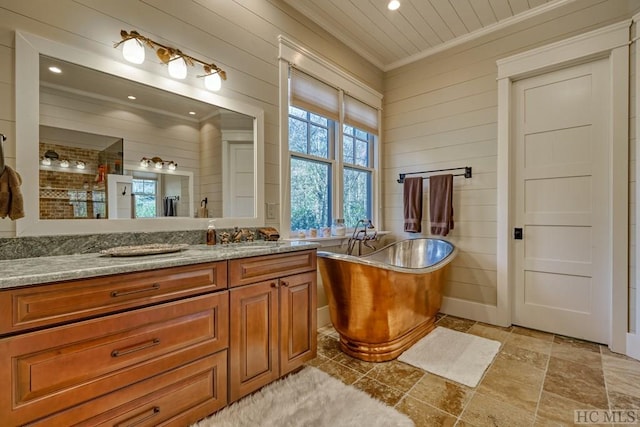bathroom with vanity, crown molding, a bath, and wooden walls