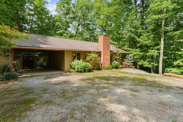 293 Gem Creek Rd, Cullowhee, NC 28723 - view of front of home with a chimney, driveway, roof with shingles, and a carport