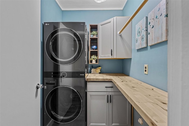 washroom with stacked washer and dryer and cabinets