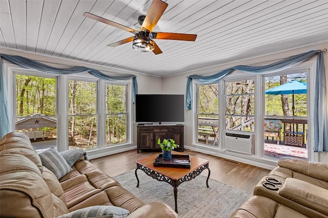 sunroom with cooling unit, wood ceiling, a wealth of natural light, and ceiling fan