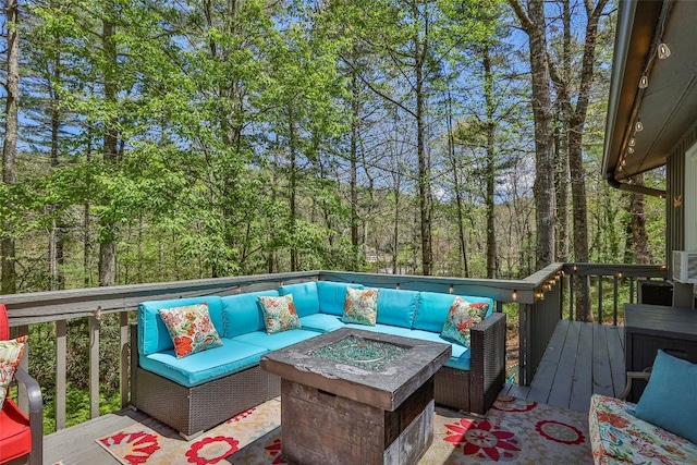 deck featuring an outdoor living space with a fire pit