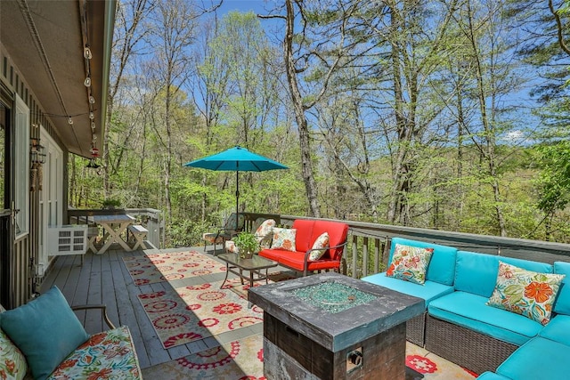 deck featuring an outdoor living space with a fire pit