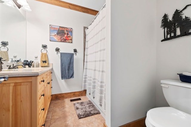 bathroom with visible vents, toilet, vanity, baseboards, and tile patterned floors