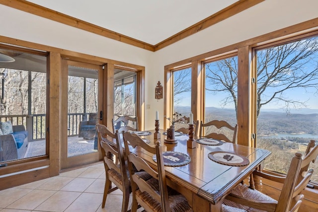 dining room with light tile patterned floors and crown molding