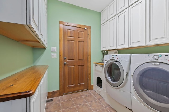 clothes washing area with light tile patterned floors, a sink, cabinet space, and washer and dryer