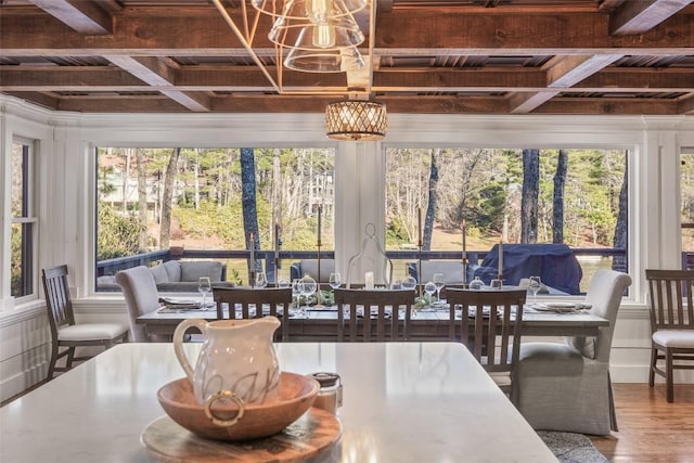 sunroom featuring beamed ceiling, coffered ceiling, and a notable chandelier