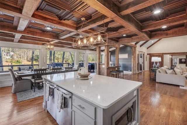 kitchen featuring a center island, a notable chandelier, light wood-style floors, open floor plan, and coffered ceiling