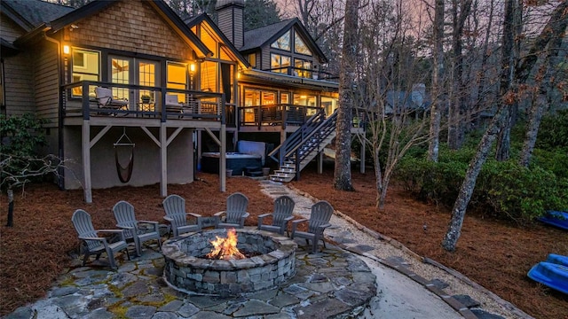 back of property featuring a patio, a chimney, stairway, an outdoor fire pit, and a deck