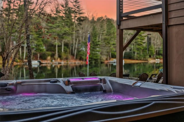 exterior space with a water view and a hot tub