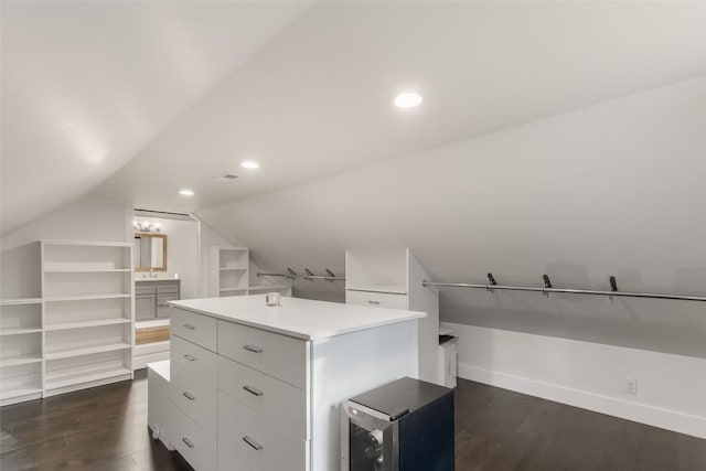 walk in closet featuring dark wood-style floors, beverage cooler, and lofted ceiling