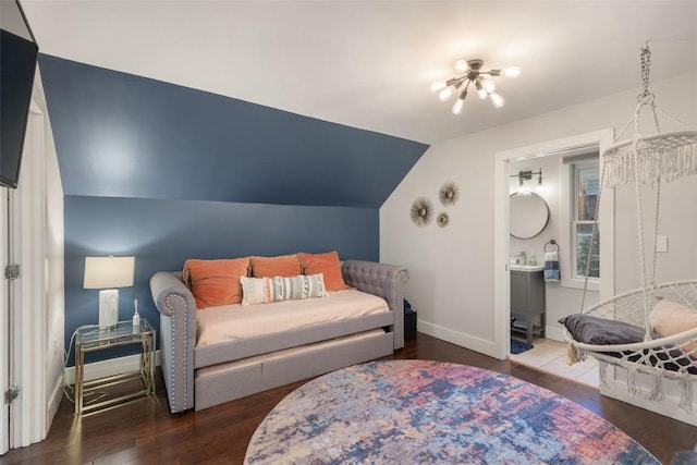 bedroom featuring a chandelier, vaulted ceiling, baseboards, and wood finished floors